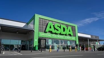 Front of a shopping centre, which has a large sign over the front door that reads ASDA in large green capital letters.